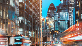 London business district at night with red London buses