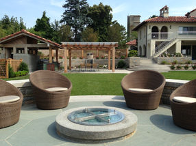 outdoor living design with bluestone patio, fire feature, pergola, and landscape installation in Massachusetts