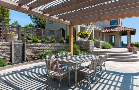 outdoor living space with pergola, bluestone patio, granite steps, retaining wall, custom planter boxes, and water feature in Massachusetts