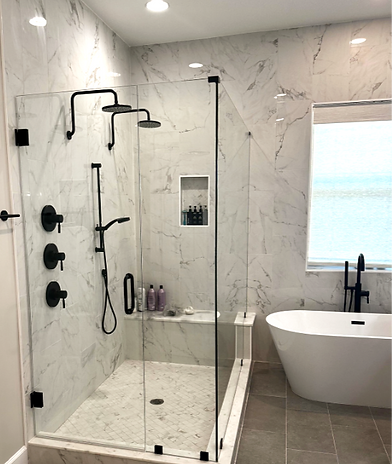 A bathroom with tile walls, a walk in shower, double shower heads, gray tile floors, stand alone tub.