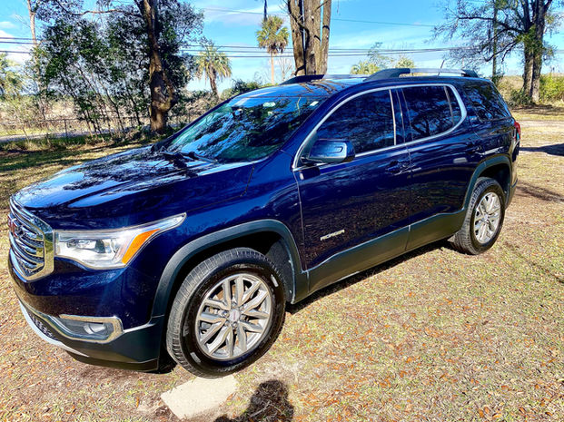 After image of a Dark Blue GMC Acadia from the driver's side, completely cleaned and glossy following The Essentials Detail.