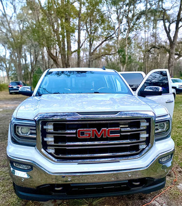 After image of the front view of the GMC Sierra with a glossy, reflective hood and windshield, showing a major transformation with the driver door open.