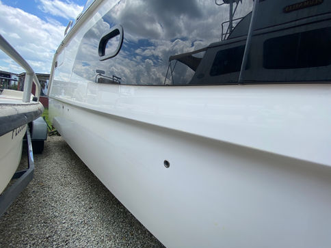 A detailed view of the Aquila catamaran’s hull after algae removal, showing smooth, white fiberglass with no remaining growth.