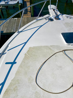 Progress shot of a boat deck showing cleaned bright white section and dull green section, highlighting the difference in cleanliness during the detailing process.