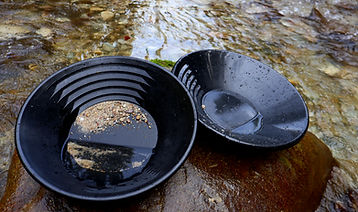 Goldwaschpfanne am Wasser