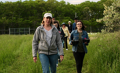 Carol Russell, Emily Murphy, and others walking down a path at Carol's farm.