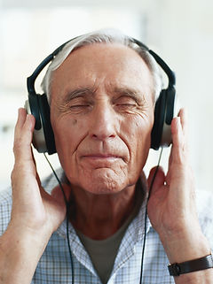 Un retraité écoute de la musique modifié avec la technique de l'holopsonie pour se détendre et améliorer son bien-être