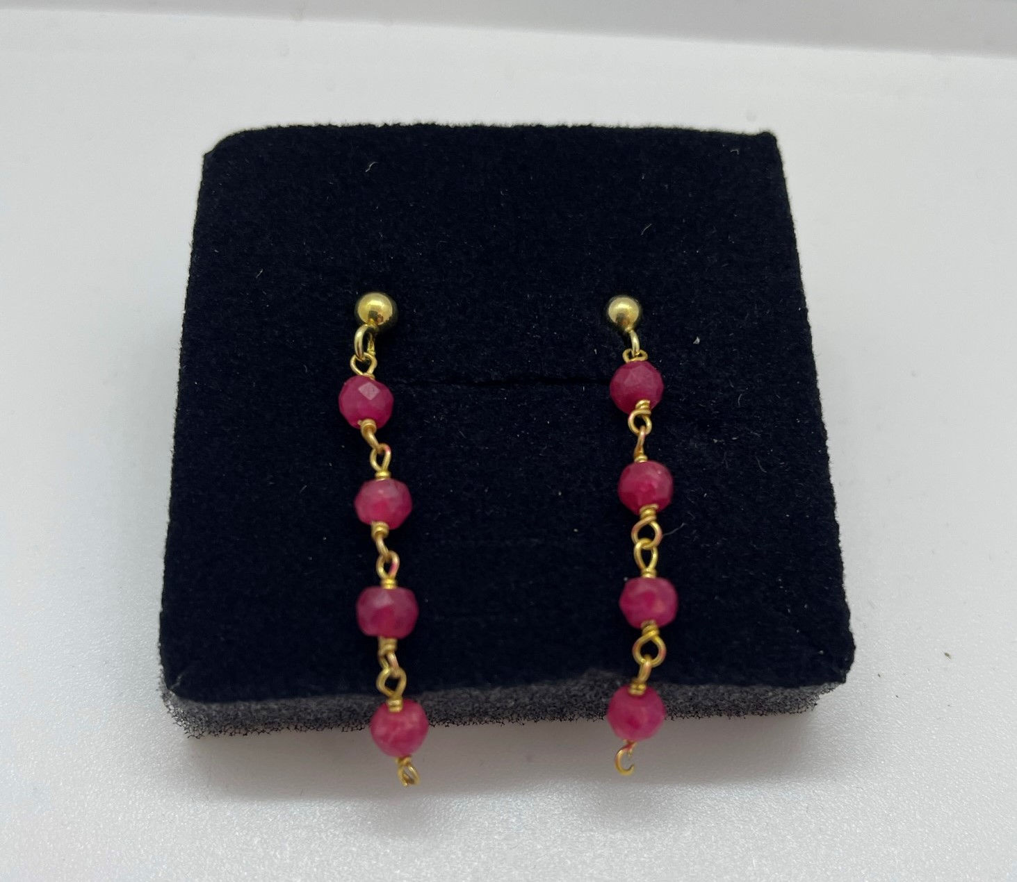 Goud op zilver steker met gekettelde robijntjes