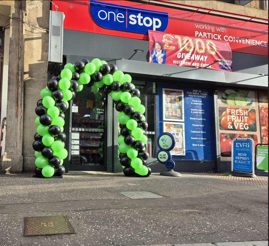 Black and green balloon arch outside One Stop shop