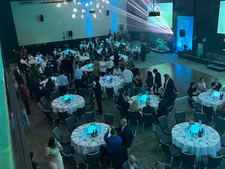 The UK Business Tech Awards 2026 gala dinner venue at the London Hilton Bankside, with round tables set and blue stage lighting ahead of the ceremony