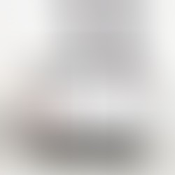 A laptop on a clean white desk displaying the Hylark hobby community workspace, surrounded by dried flowers and a glass of water.