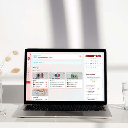 A laptop on a clean white desk displaying the Hylark hobby community workspace, surrounded by dried flowers and a glass of water.