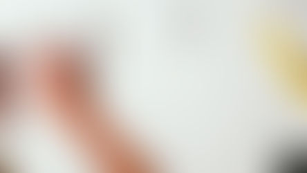 a woman typing on a white keyboard, with an apple mouse and yellow wristwatch beside her