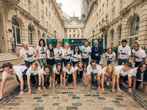 Participants at Hedley May’s fundraising event pose in running stances on a London street, celebrating efforts to support social mobility with The King’s Trust and Making The Leap.