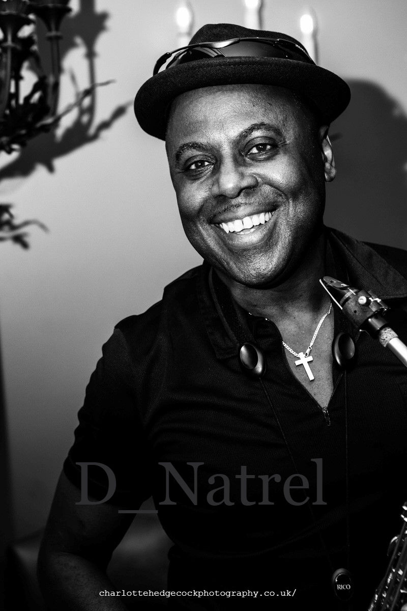 Eye-level view of D Natrel performing on stage with his saxophone