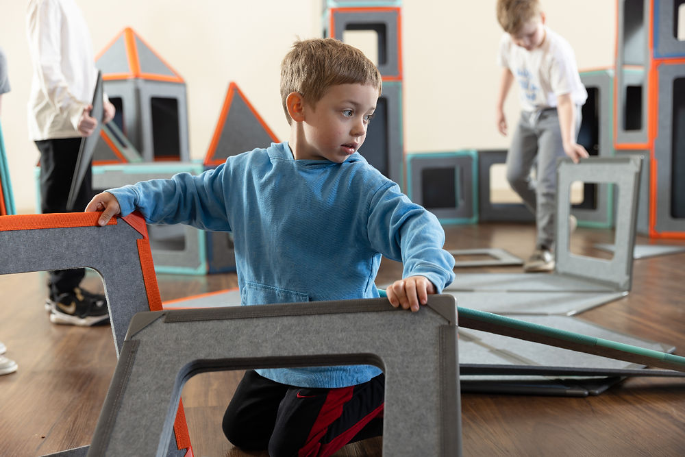 Young boy playing with building blocks in an educational superspace for educators.