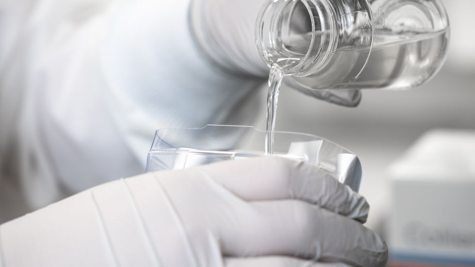 A scientist pouring water in an IDEXX test