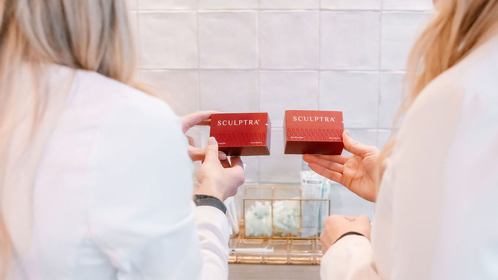 Two people in white coats hold red Sculptra boxes in a clinical setting. Tiled wall and skincare products in the background.
