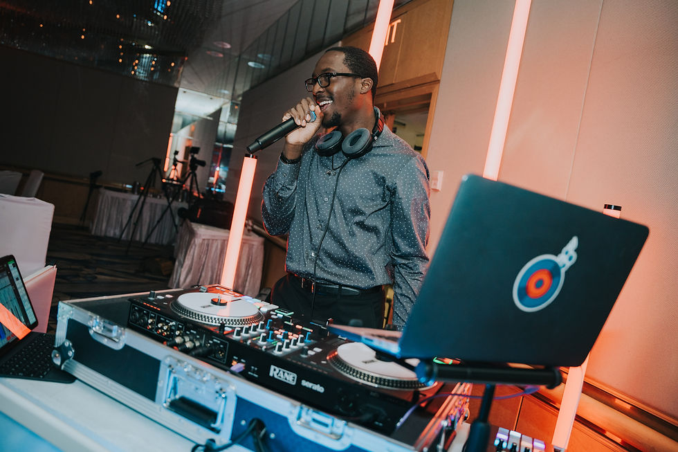 Close-up view of DJ hands adjusting a mixer beside a wedding timeline and wireless microphone