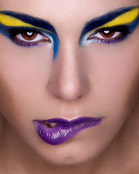 Beauty portrait with graphic blue & yellow eye makeup and purple lips