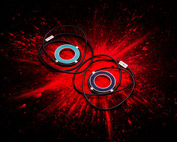 Red circular accessories and black cords surrounded by an exploding red powder effect