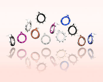 Collection of colourful circular accessories arranged on a pale pink background