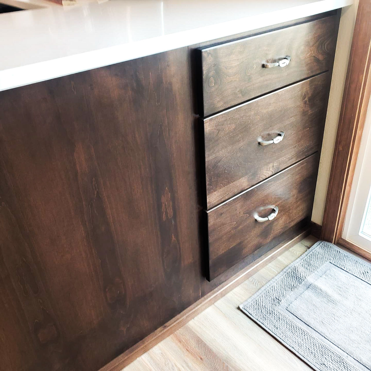 Kitchen with dark wood cabinets and white countertops