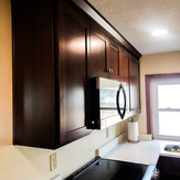 Kitchen with dark wood cabinets and white countertops