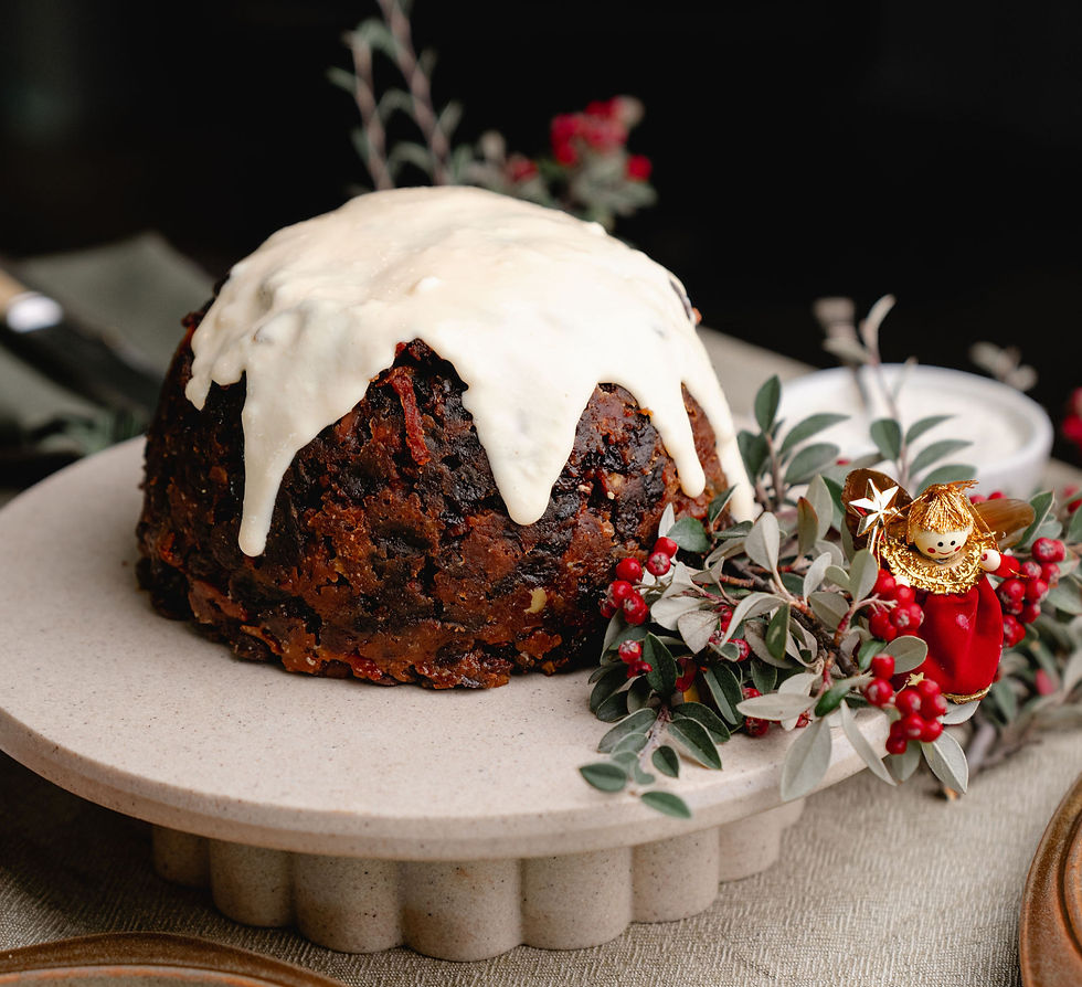 Wide-angle view of a dark gluten-free Christmas pudding on a ceramic plate.
