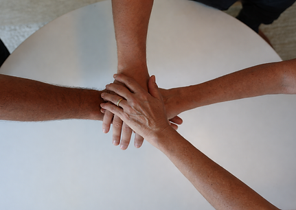 Hands of unity on a table.png