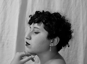 imagem preta e branco de uma mulher jovem, cabelos curtos e brinco de gota de perfil>autora do blog>nathaliaromae>nonhilum