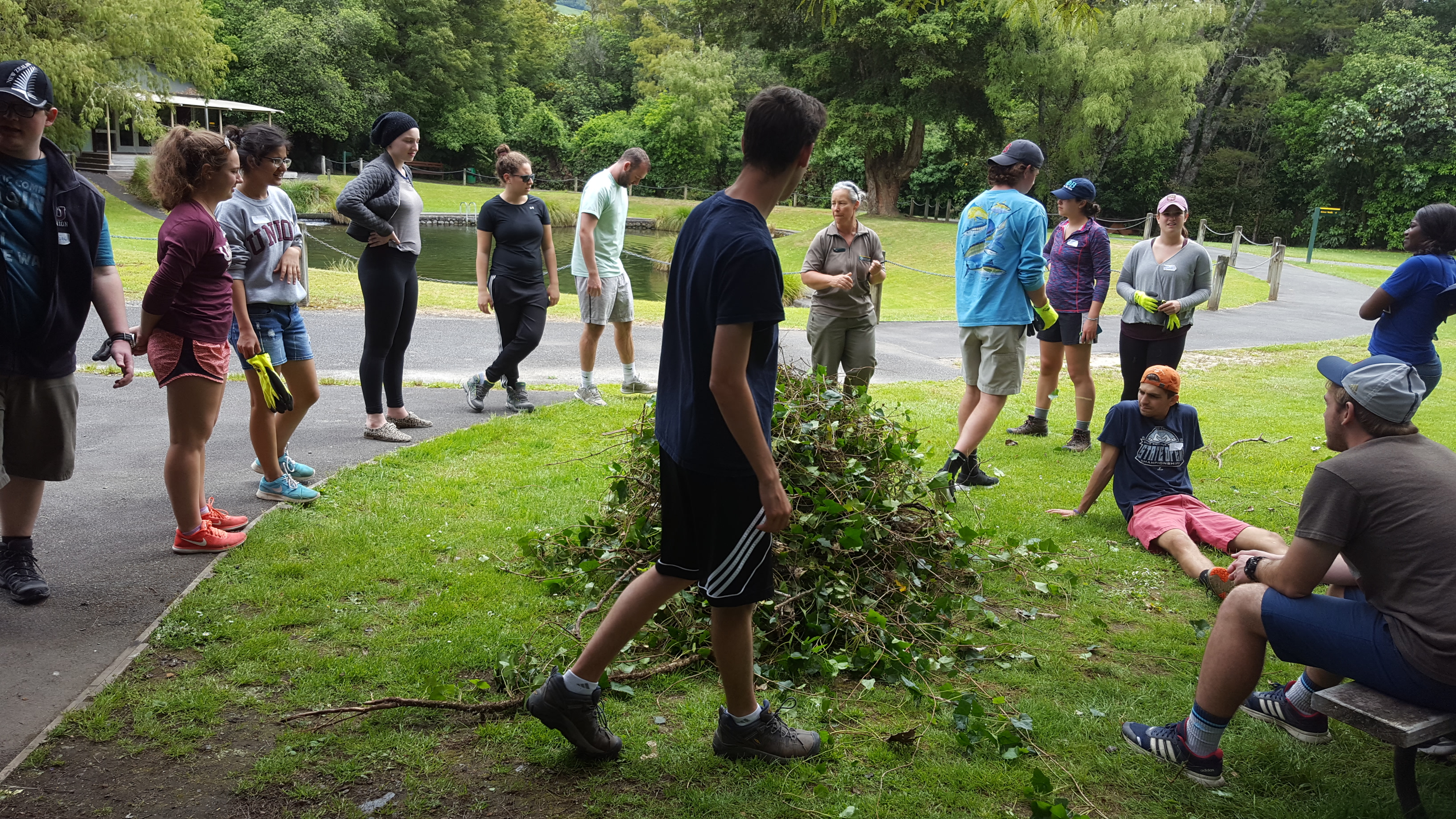 People standing around pile of weeds
