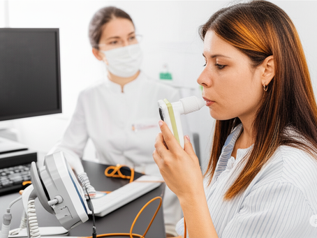 Mujer realizándose prueba de espirometrÃa en Sia Salud, Ibagué. Profesional médico analiza resultados con equipo moderno para detectar EPOC, asma ocupacional y mejorar salud respiratoria en ambientes laborales.