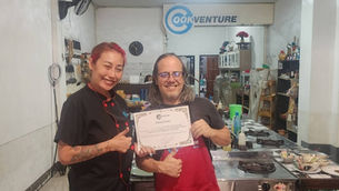Chef Apple presenting a graduation certificate to a happy student at our DTV cooking class in Chiang Mai.