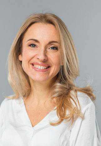 smiling-portrait-of-blonde-young-businesswoman-standing-against-gray-background_edited.jpg