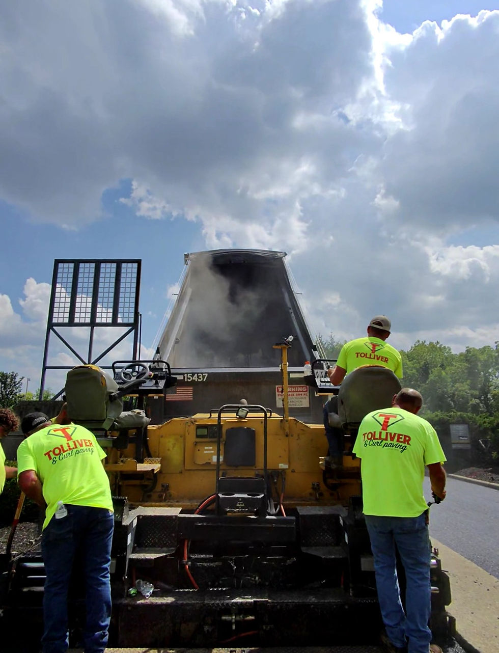 Paving crew working on one section of a parking lot while the rest stays open