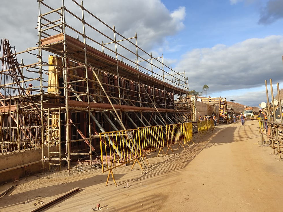 Andaimes multidirecionais instalados em ambos os lados de estrutura de obra linear em construção pesada.