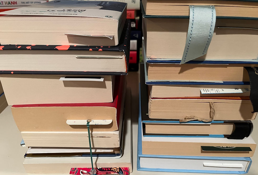 A pile of books with bookmarks at various points in each book.