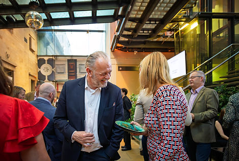 Guests networking and talking at a corporate event in a modern indoor venue.