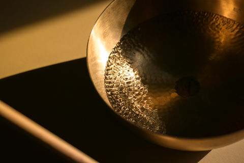 Close-up of a golden singing bowl, reflecting light in a warm, inviting way