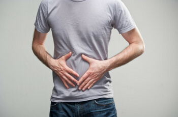 Man holding stomach.