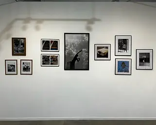 A wall of the art gallery shows a collection of paintings and drawings from the gallery exhibition.