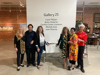 Six people are standing in front of the entrance to the gallery. The gallery wall has the name of the group exhibiting, "gallery 25" and the names of the five artists below the title.