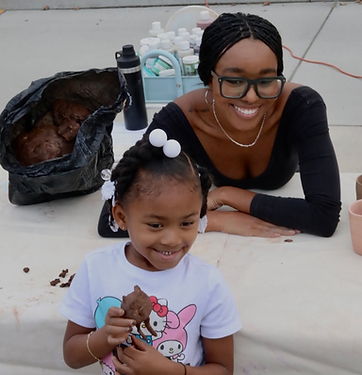 A happy little girl is holding a clay animal figure she made