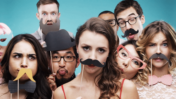 Groupe d'amis s'amusant avec des accessoires photobooth originaux