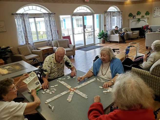 Residents enjoy a friendly game of dominoes, sharing laughter and connection in our assisted living community.