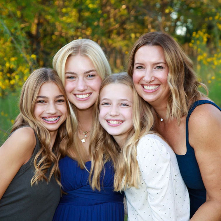 Mom and three beautiful daughters smiling for outdoor photoshoot in Kansas City