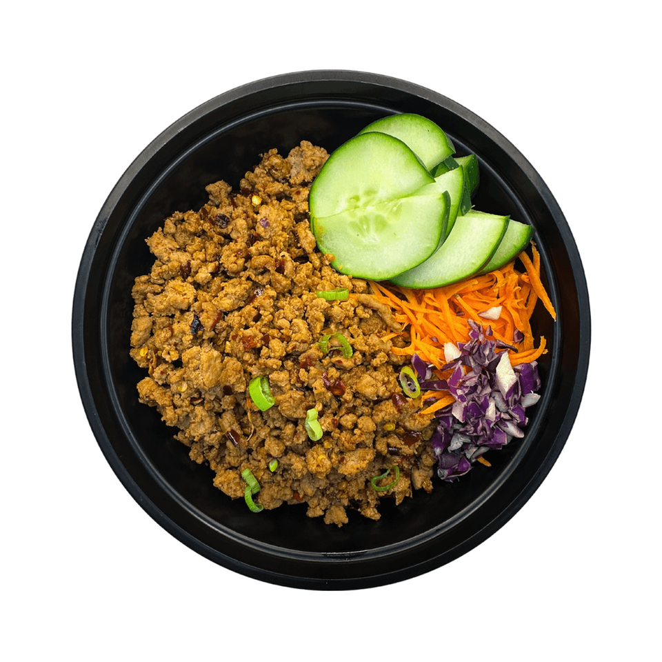 The LunaFit Fresh Spicy Thai Basil Ground Turkey Bowl Meal features a round black bowl filled with dark, savory ground turkey cooked with visible, wilted green Thai basil leaves and red chili flakes, served over a bed of white jasmine rice.