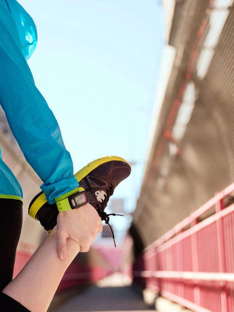 Runner performing a quad stretch as part of a pre-run warm-up routine