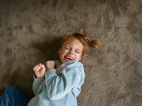 Lachendes Mädchen auf Teppichboden